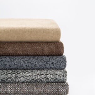 stack of upholstery fabrics on a white background